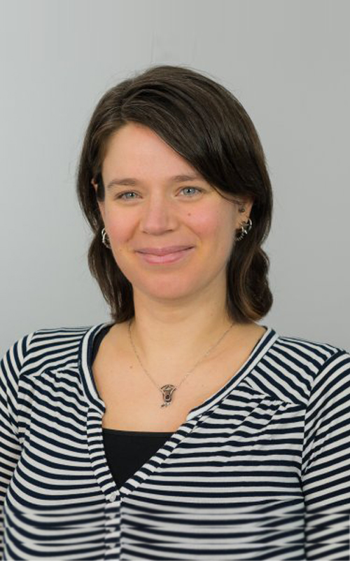 a woman in a striped shirt and smiling at the camera