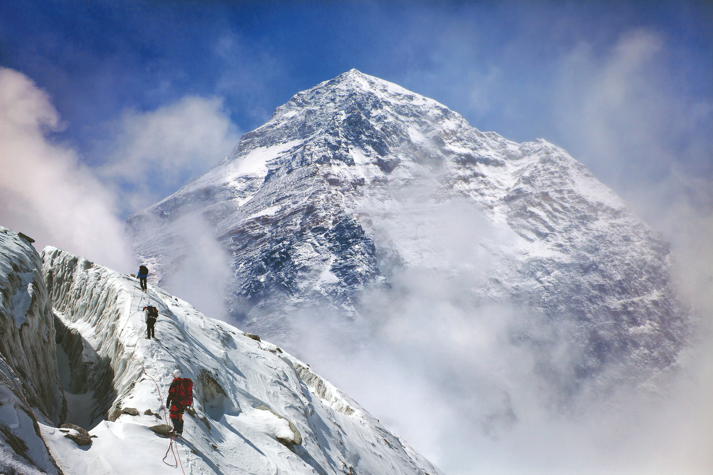a group of people riding skis down a snow covered mountain