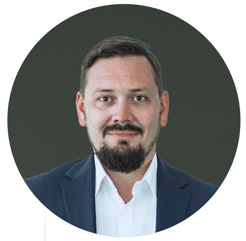a man wearing a suit and tie smiling and looking at the camera